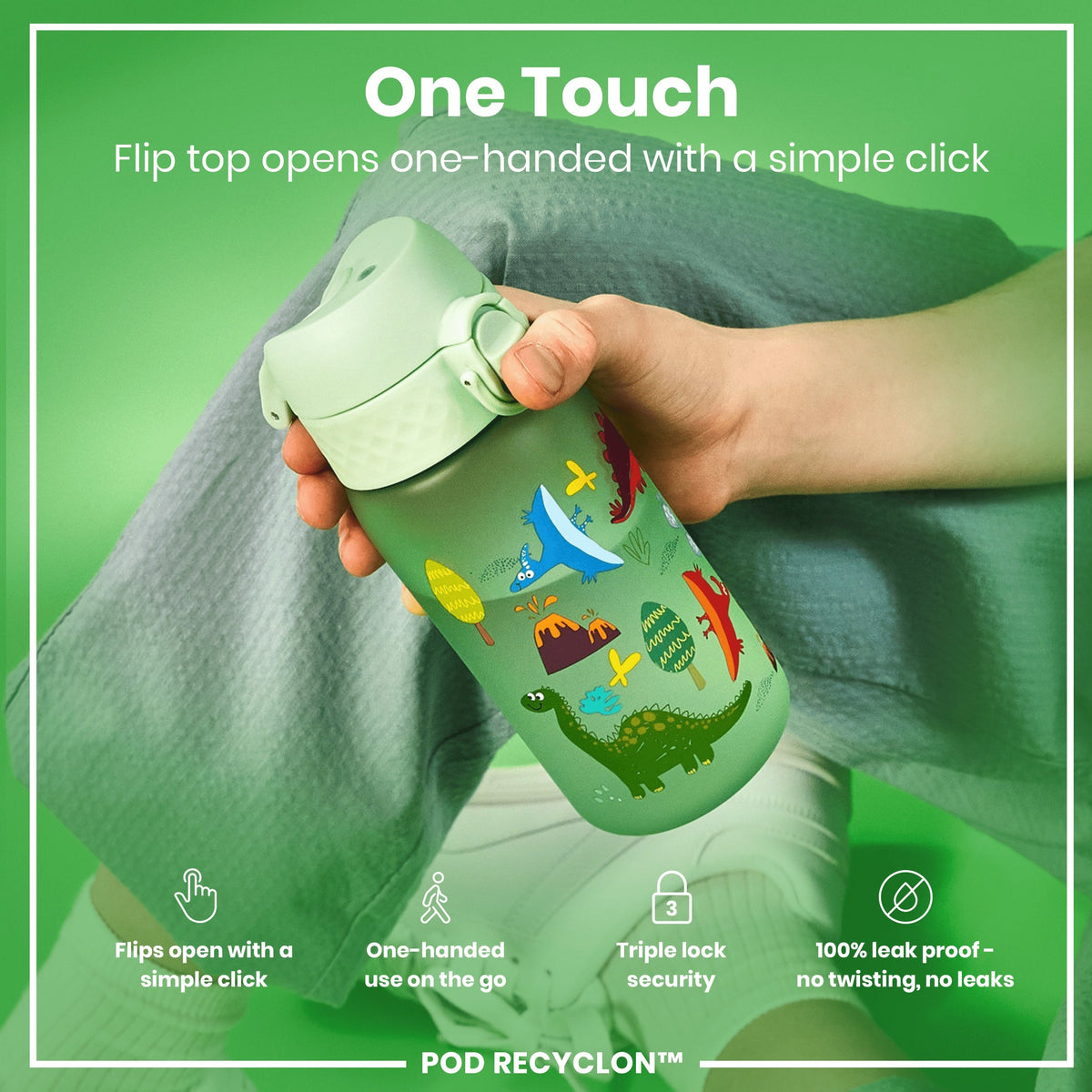 A light green water bottle, featuring dinosaur illustrations, is being held. Its flip top opens one-handed; it’s leak-proof and has triple lock security. The bottle is shown against a green backdrop.