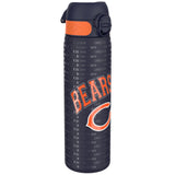 A dark-blue water bottle, featuring an orange band and the Chicago Bears logo, sits against a white background. The bottle is covered in a repeating pattern of 
