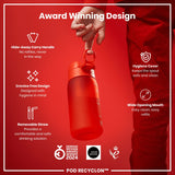 A red water bottle is held by a person against a red background. Features include a hide-away handle, crevice-free design, removable straw, hygiene cover, and wide mouth. The bottle is an award-winning design, a 2024 German Design Award winner. POD RECYCLON™