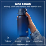 A blue water bottle is being held; its flip top opens one-handed. The bottle features a triple lock security mechanism, is leak-proof, and is shown against a blue background. 