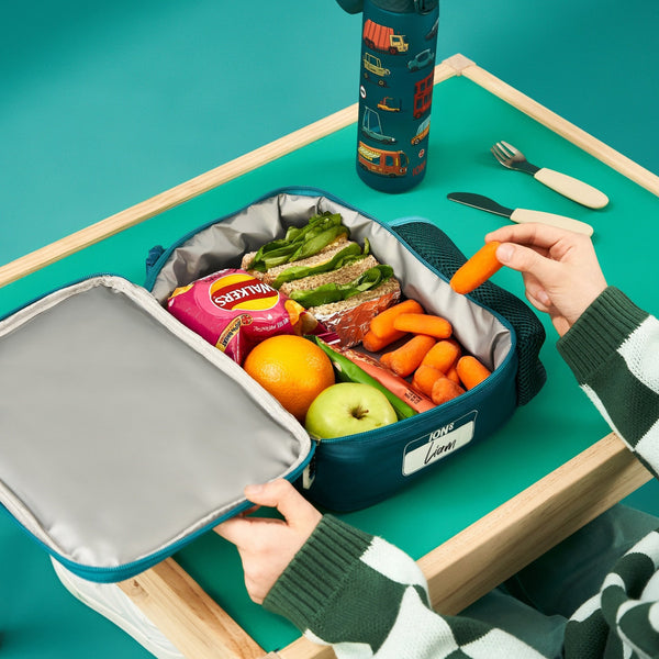 A rectangular teal lunchbox showcases colorful cartoon vehicles including cars, buses, and trucks with road signs such as "Stop" and "A68" in a playful pattern.